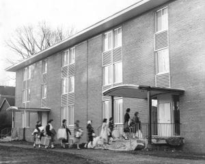 Women entering a three story brick building.