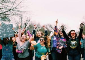 Group of Alpha Delta Pi sorority members celebrating with their hands up.